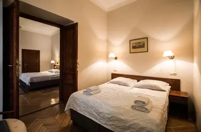 a hotel room with two beds and a mirror at Aparthotel Basztowa in Kraków