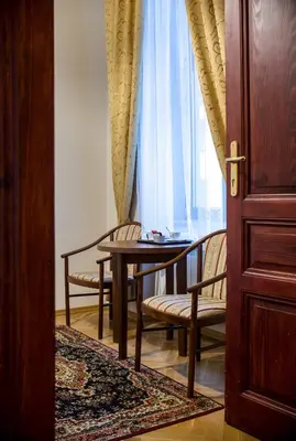 a table and chairs in a room with a window at Aparthotel Basztowa in Kraków