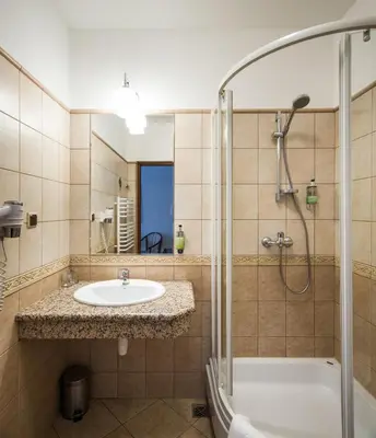 a bathroom with a sink and a shower at Aparthotel Basztowa in Kraków