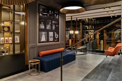 a store with a blue couch and orange chairs at Garamond, a Tribute Portfolio Hotel, Krakow Old Town in Kraków