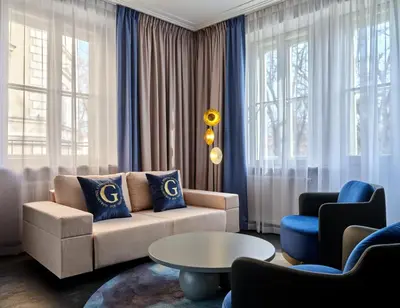 a living room with a couch and a table at Garamond, a Tribute Portfolio Hotel, Krakow Old Town in Kraków