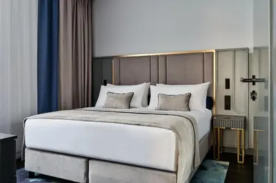 a bedroom with a large white bed with two pillows at Garamond, a Tribute Portfolio Hotel, Krakow Old Town in Kraków
