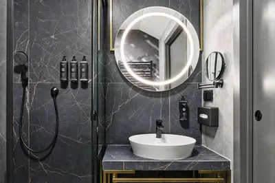 a bathroom with a sink and a mirror at Garamond, a Tribute Portfolio Hotel, Krakow Old Town in Kraków