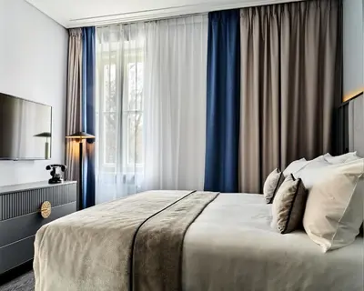 a bedroom with a large bed and a window at Garamond, a Tribute Portfolio Hotel, Krakow Old Town in Kraków
