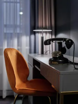 a desk with a telephone and a chair at Garamond, a Tribute Portfolio Hotel, Krakow Old Town in Kraków