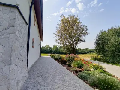a walkway next to a building with flowers at Winnica NOVI - apartamenty in Cianowice Duże