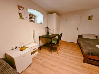 a bedroom with a desk and a bed and a table at Winnica NOVI - apartamenty in Cianowice Duże