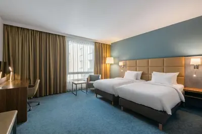 a hotel room with two beds and a desk at Radisson Blu Hotel Krakow in Kraków