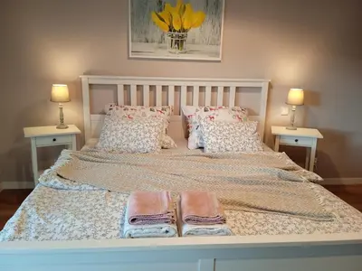 a large bed with two pillows and two tables at Domek Mordarka in Limanowa