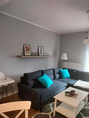 a living room with a blue couch and a table at Domek Mordarka in Limanowa