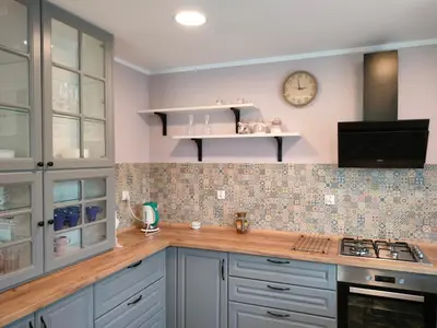 a kitchen with blue cabinets and a clock on the wall at Domek Mordarka in Limanowa