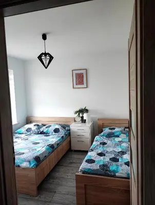a bedroom with two twin beds and a dresser at Apartamenty NOVA in Zator