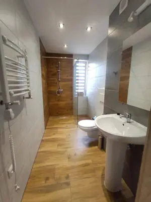 a bathroom with a white sink and a toilet at Apartamenty NOVA in Zator