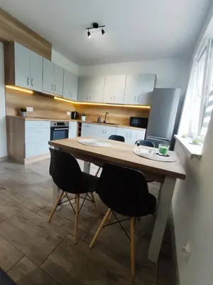 a kitchen with a large wooden table and chairs at Apartamenty NOVA in Zator