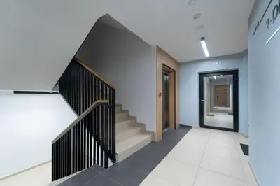 a hallway with stairs leading to a door at Doris Day Apartment in Kraków