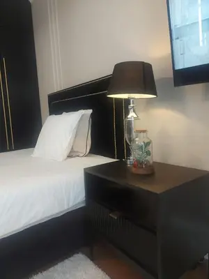 a bedroom with a bed with a lamp and a nightstand at Doris Day Apartment in Kraków