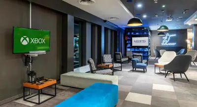 a hotel room with two beds and a desk at Novotel Kraków City West in Kraków