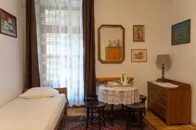 a bedroom with a bed and a table and a mirror at Kolory Guest House in Kraków