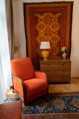 an orange chair and a lamp in a room at Kolory Guest House in Kraków