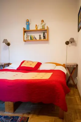 a bedroom with a bed with a red blanket at Kolory Guest House in Kraków