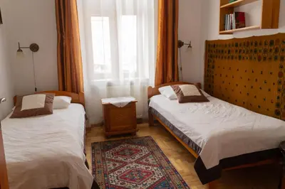 two beds in a room with a window at Kolory Guest House in Kraków