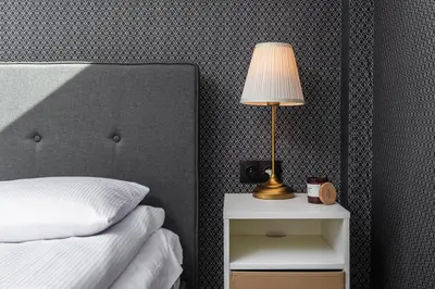 a bedroom with a bed and a lamp on a night stand at Riverside Premium Class Apartment - by Upstairs in Kraków