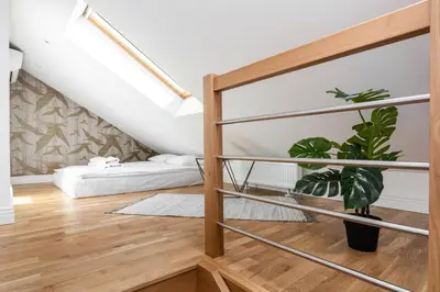 a staircase in a living room with a plant at Riverside Premium Class Apartment - by Upstairs in Kraków