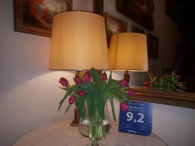 a vase of flowers sitting on a table with a clock at Willa Marysin in Maków Podhalański