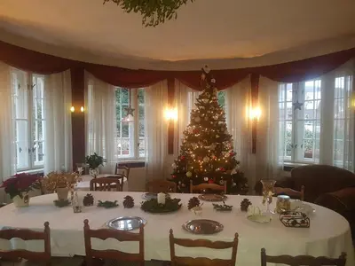 a christmas tree in a dining room with a table at Willa Marysin in Maków Podhalański