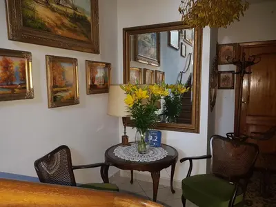 a room with a table with a vase of yellow flowers at Willa Marysin in Maków Podhalański