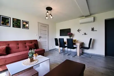 a living room with a red couch and a table at HOUSE OF ENERGY - Zator Przeciszów in Przeciszów