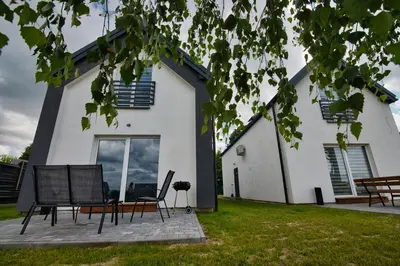 a house with chairs and a table in front of it at HOUSE OF ENERGY - Zator Przeciszów in Przeciszów