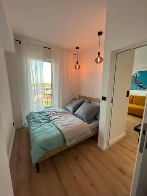 a bedroom with a bed and a large window at Apartament 4 piętro in Zator