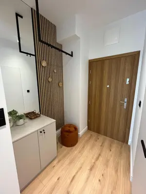 a hallway with a wooden door in a room at Apartament 4 piętro in Zator