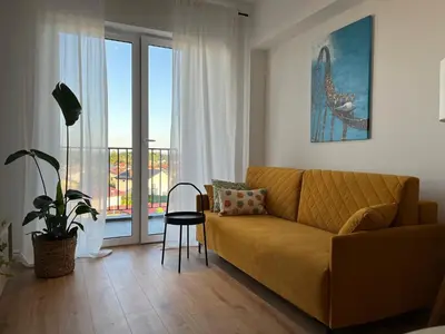 a living room with a couch and a balcony at Apartament 4 piętro in Zator