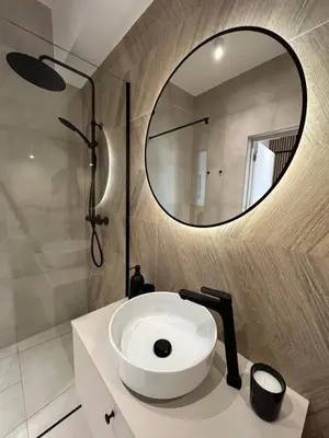 a bathroom with a white sink and a mirror at Apartament 4 piętro in Zator