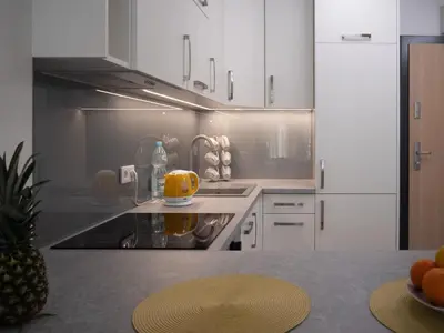 a kitchen with white cabinets and a stove top oven at Przytulny apartament z ogródkiem in Kraków