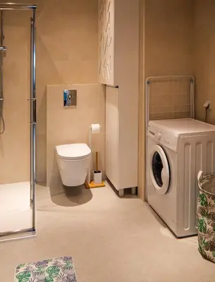 a bathroom with a washing machine and a toilet at Przytulny apartament z ogródkiem in Kraków