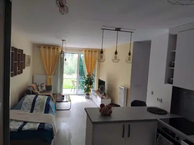 a room with a kitchen and a living room at Przytulny apartament z ogródkiem in Kraków