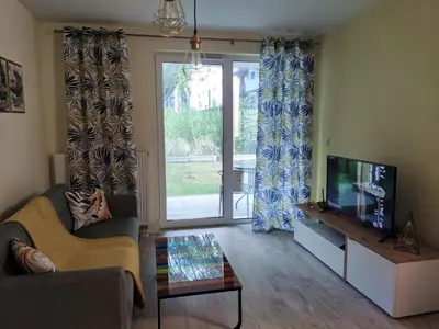 a living room with a couch and a tv at Przytulny apartament z ogródkiem in Kraków