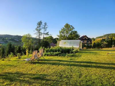 two chairs sitting in the grass in a field at Apartament u Ewki in Rdzawka