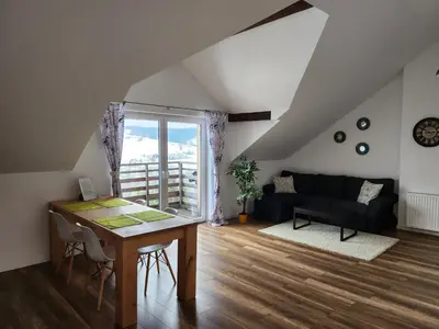 a living room with a table and a couch at Apartament u Ewki in Rdzawka