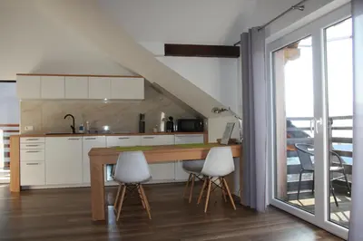 a kitchen with white cabinets and a table and chairs at Apartament u Ewki in Rdzawka