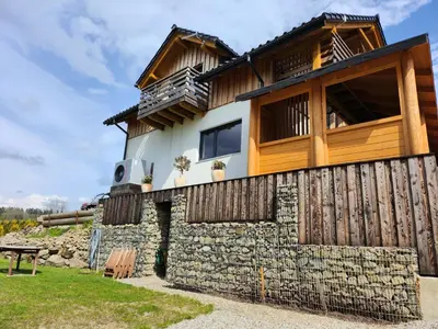 a house built on a stone wall with a balcony at Apartament u Ewki in Rdzawka