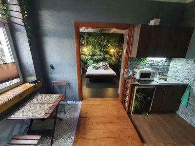 a room with a kitchen with a sink and a table at Tropicana Jacuzzi Apartment in Kraków