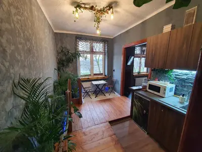a kitchen with a counter and a table and a microwave at Tropicana Jacuzzi Apartment in Kraków