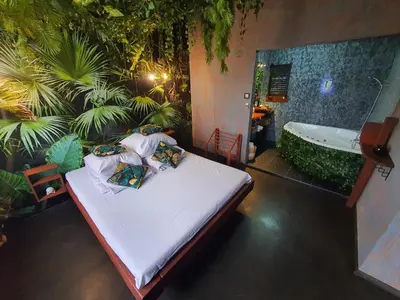 a bedroom with a bed and a bath tub at Tropicana Jacuzzi Apartment in Kraków