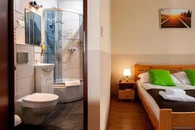 a bathroom with a bed and a shower and a toilet at Station Aparthotel in Kraków