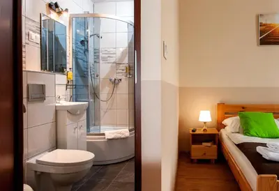 a bathroom with a shower and a toilet and a sink at Station Aparthotel in Kraków