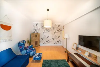 a living room with a blue couch and a tv at Urocze mieszkanie w krakowskiej kamienicy in Kraków